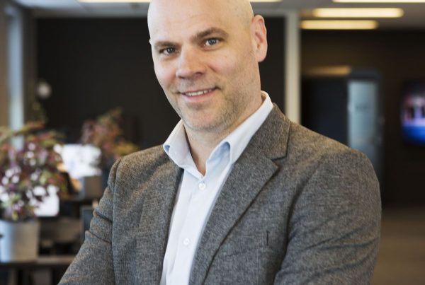 Robert Lundsten standing in an office with his arms crossed.